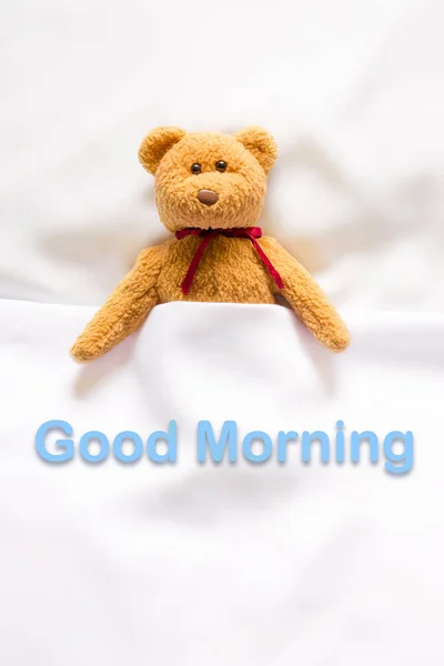 Teddy Bear lying in the white bed with message " Good morning " — Stock Photo, Image
