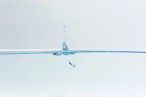 Stříkající vodě s bublinkami vzduchu, izolovaných na bílém pozadí — Stock fotografie