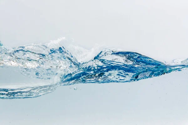 Stříkající vodě s bublinkami vzduchu, izolovaných na bílém pozadí — Stock fotografie