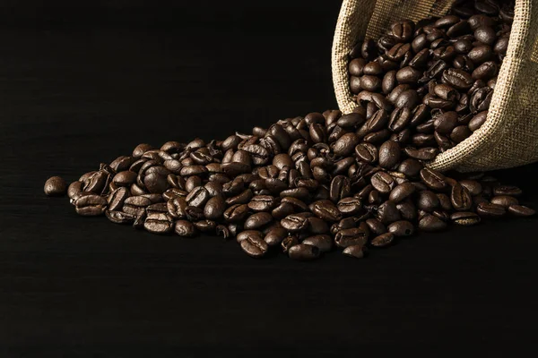 Κόκκος καφέ σε μαύρο φόντο ξύλου — Φωτογραφία Αρχείου