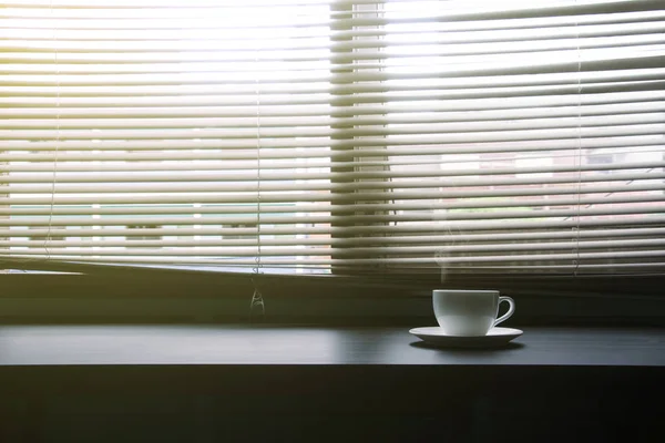 Tasse de café est situé près de la fenêtre — Photo