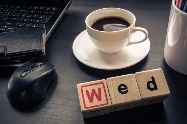 Taza de café en el escritorio con madera de cubo Ordenar por día —  Fotos de Stock