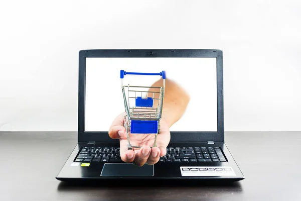 Carrinho de compras na mão com computador notebook tela em branco no woo — Fotografia de Stock