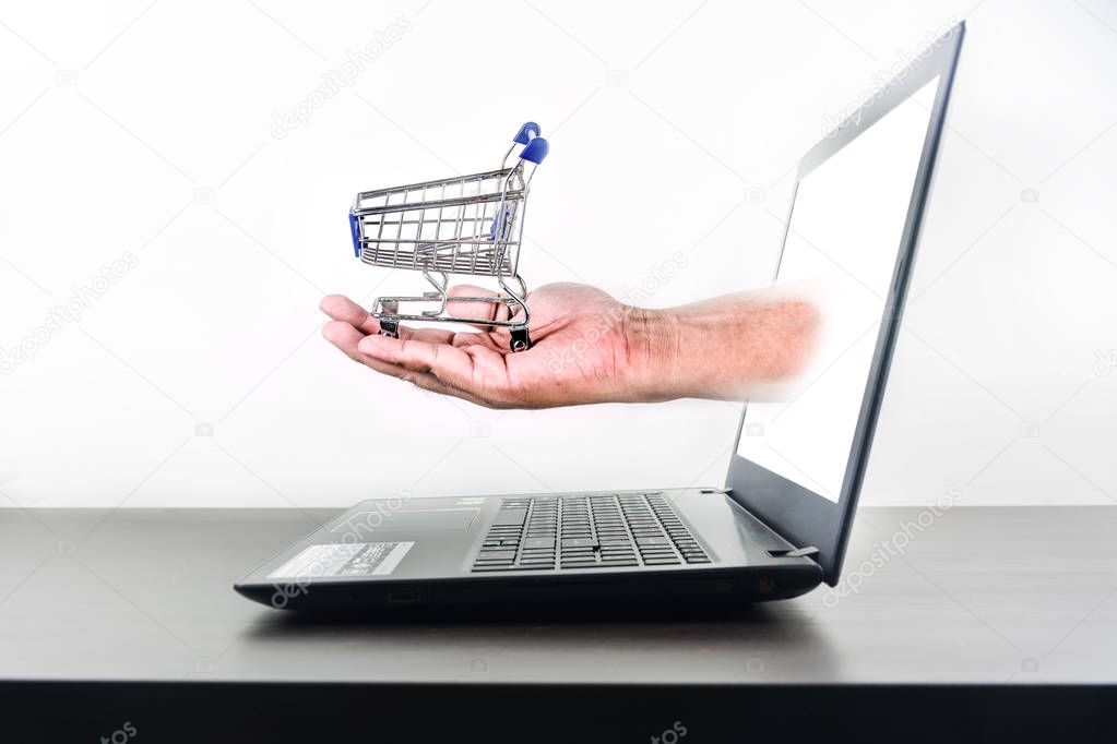 shopping cart in hand Computer notebook blank screen on wood tab