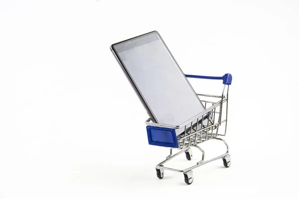 Telefone inteligente com carrinho de compras no fundo branco, significa shopp — Fotografia de Stock