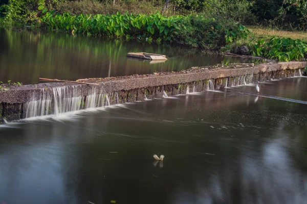Kleine irrigatie dam met water stroomt — Stockfoto