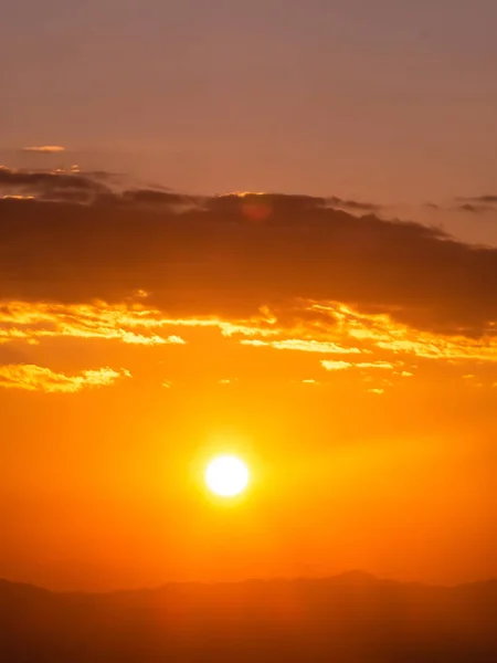 Starker Sonnenaufgang mit Silberstreifen und Wolken am orangen Himmel — Stockfoto