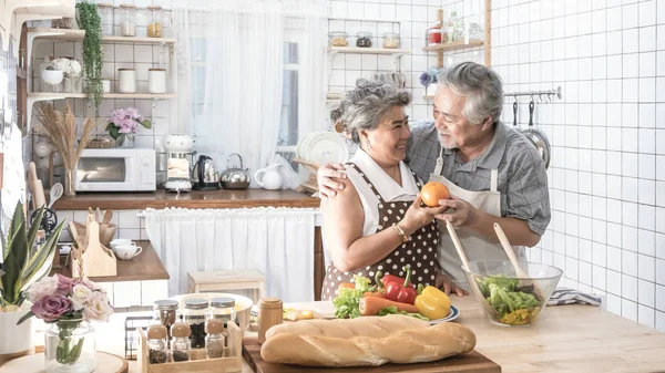 Senior pareja está cocinando en la cocina y sonriendo mientras cookin — Foto de Stock