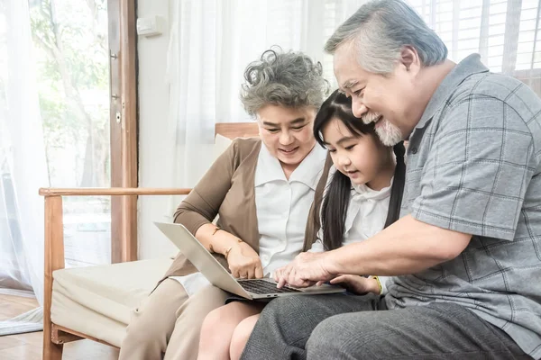 Abuelo y abuela jugando al ordenador con la chica — Foto de Stock