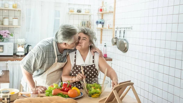 Senior pareja está cocinando en la cocina y sonriendo mientras cookin — Foto de Stock