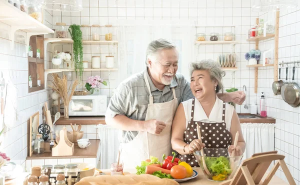Senior pareja está cocinando en la cocina y sonriendo mientras cookin — Foto de Stock