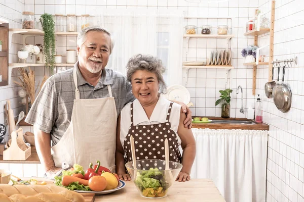 Senior pareja está cocinando en la cocina y sonriendo mientras cookin — Foto de Stock