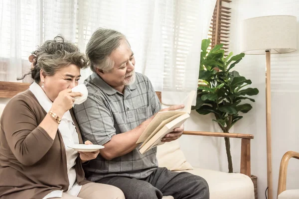 Asiático anciano pareja sentado juntos en la sala de estar de lectura — Foto de Stock