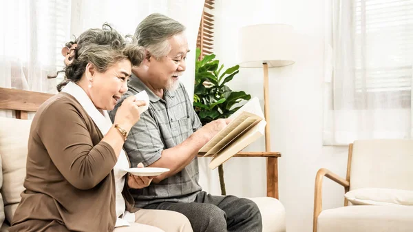 Asiático anciano pareja sentado juntos en la sala de estar de lectura — Foto de Stock