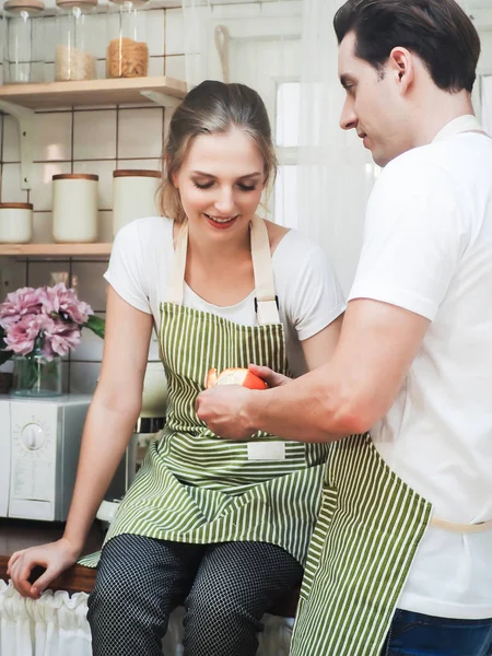 A man peeling fruit and woman is looking , Concept lover , coupl