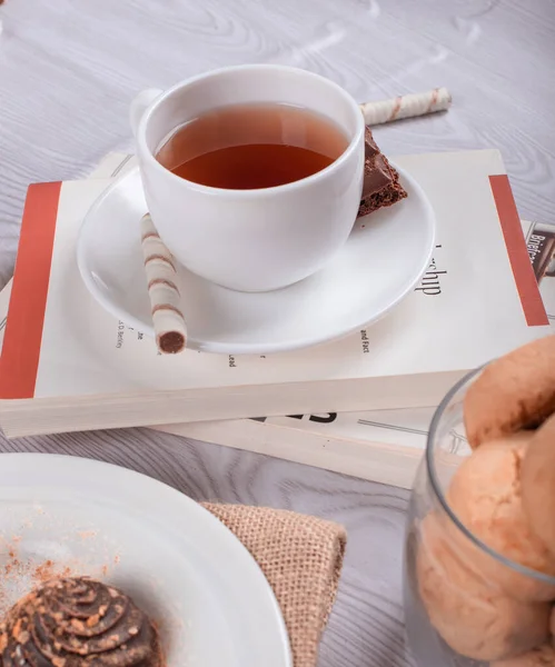 Buch, Schokolade und Tee auf dem Tisch — Stockfoto