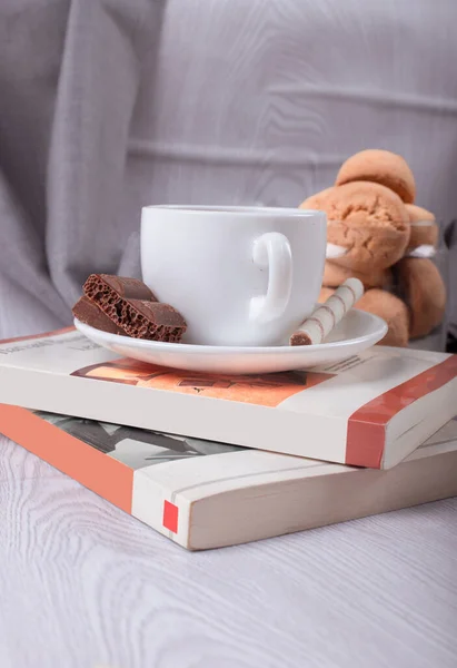 Süße Snacks, Tasse Tee und Schokolade und Buch auf dem Tisch — Stockfoto