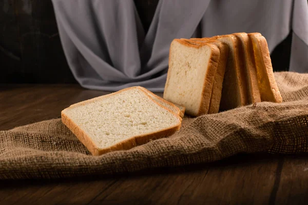 Kromki chleba na drewnianym stole — Zdjęcie stockowe