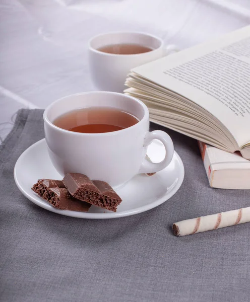 Book, Sweet snacks and cup of tea on the table Stock Image