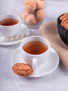 Tatlı atıştırmalıklar ve masada bir fincan çay.