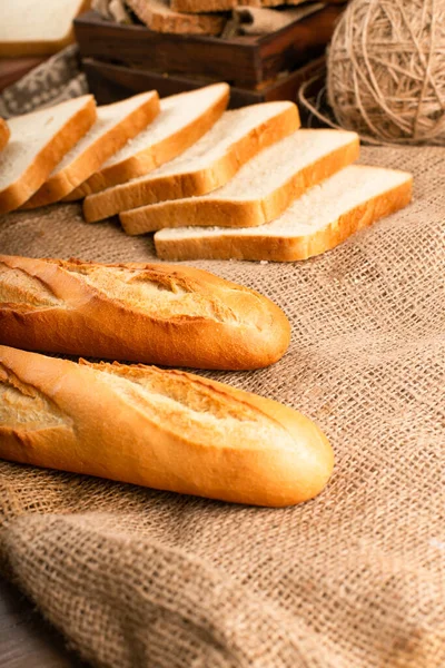 Baguete francesa com fatias de pão na toalha de mesa — Fotografia de Stock