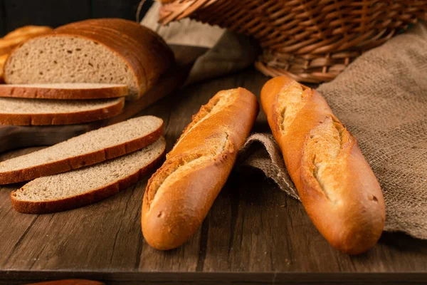 Fatias de pão marrom e branco na placa de cozinha com baguete — Fotografia de Stock