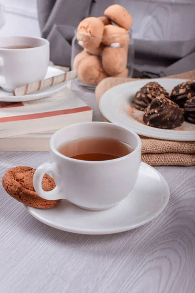 Livre, tasse de thé et chocolat sur fond clair — Photo