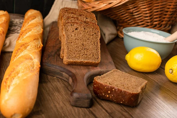 Baguete francesa com fatias de pão integral e limões — Fotografia de Stock