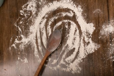 Tahta kaşıkla un, masada.