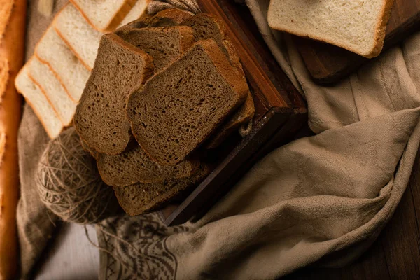 Slices of white bread brown and bread in box on kitchen board