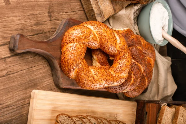 Bagels sabrosos con rebanadas de pan y tazón de harina —  Fotos de Stock