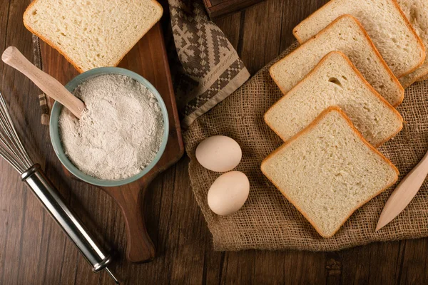 Kawałki chleba i miska mąki z jajkami — Zdjęcie stockowe