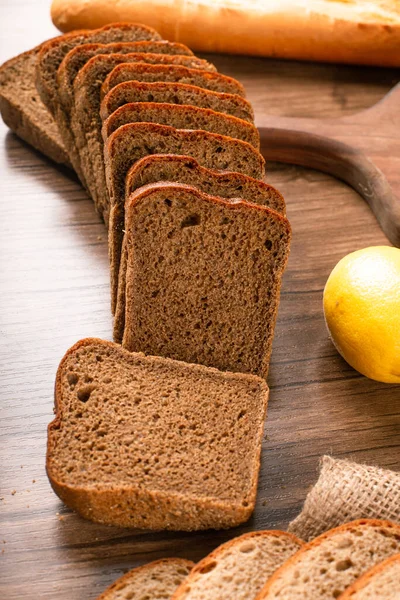 Pão marrom com limões na toalha de mesa — Fotografia de Stock