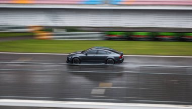 Yağmurlu yolda siyah modern tasarım spor coupe sürücüsü