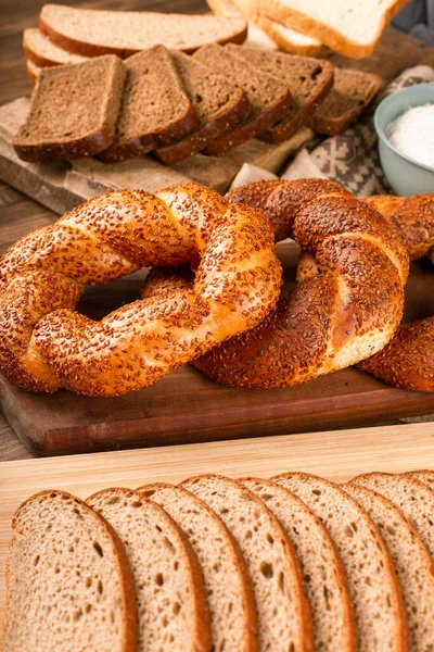 Bagel y rebanadas de pan oscuro en el tablero de la cocina —  Fotos de Stock