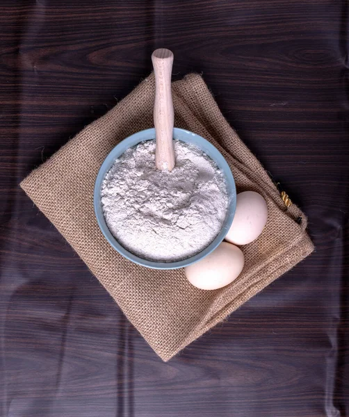 A bowl of flour with eggs on tablecloth — Stock Photo, Image