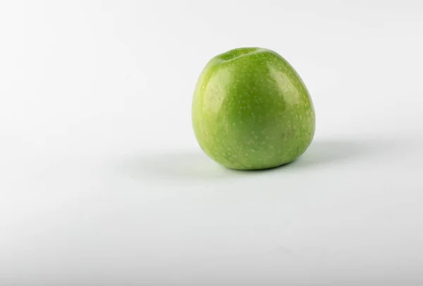 Одно зеленое свежее яблоко на белом фоне. вид сбоку — стоковое фото