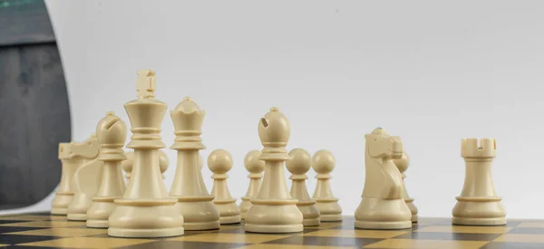 Weiße Figuren in einer Reihe auf einem Schachbrett auf isoliertem weißen Hintergrund — Stockfoto