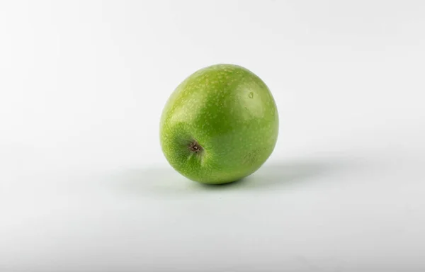 A single green fresh apple isolated on white background. shining lights on it — Stock Photo, Image