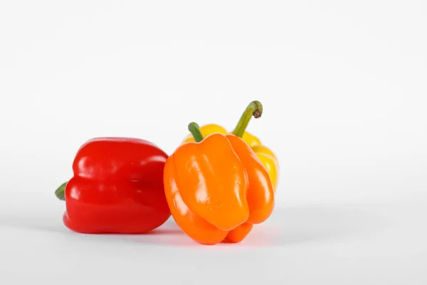 Pimentos de cor vermelha e laranja no fundo branco — Fotografia de Stock