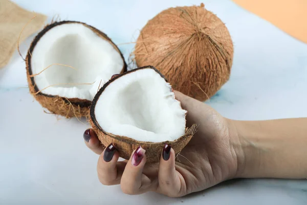 Unha vermelha polido mãos mulher segurando um coco — Fotografia de Stock