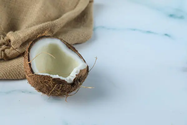 Kokosfrucht auf blauem Marmor mit Klette — Stockfoto