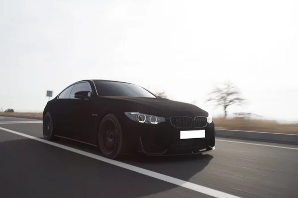Zwart chroom luxe sedan op de snelweg — Stockfoto