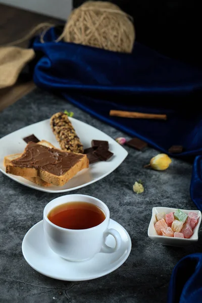 Tostadas de crema de chocolate con una taza de té en el mármol — Foto de Stock