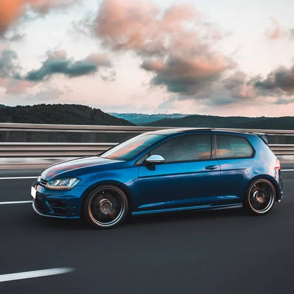 Hatchback azul en la carretera en un clima nublado — Foto de Stock