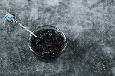 Siyah havyarlı cam bir kavanoz ve misketin üstünde kaşık.