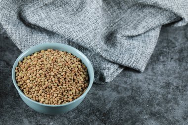 Soldaki mavi kasede yeşil taze ve sağlıklı mercimek.