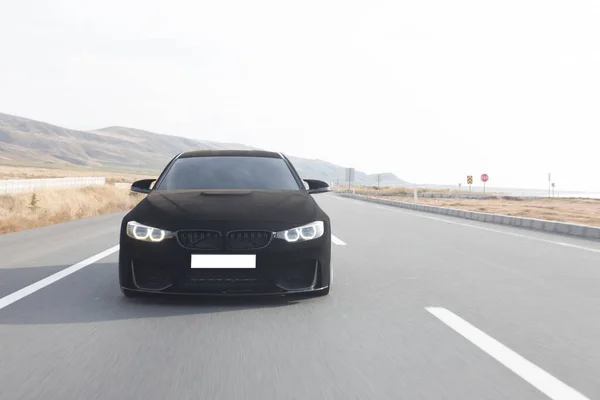 Preto cromo carro esporte de luxo dirigindo na estrada — Fotografia de Stock