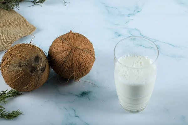 Braune Kokosnüsse und ein Glas Milch — Stockfoto