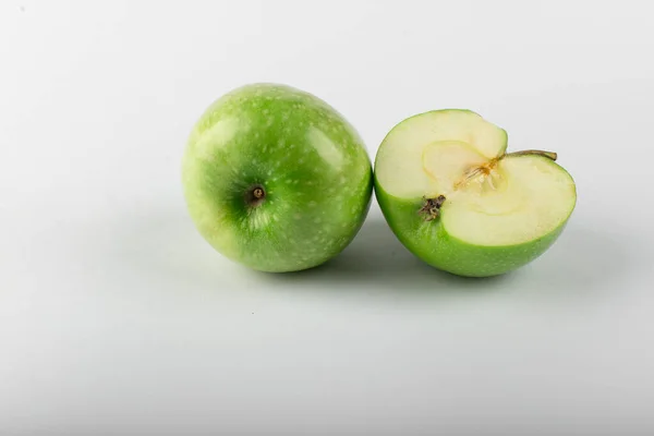 흰색으로 분리되어 있는 전체와 반쪽짜리 녹색 사과. — 스톡 사진